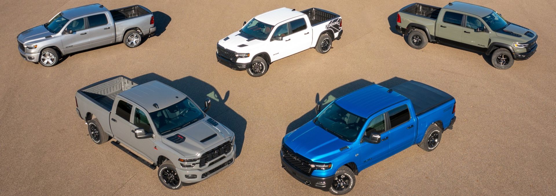a group of 2026 ram 1500s parked on sand